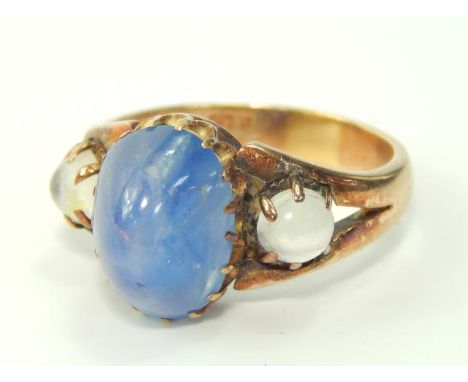 A yellow metal and cabouchon three stone ring, possible a sapphire, flanked by a pair of moonstones, size R, 7.4g, marked 15c