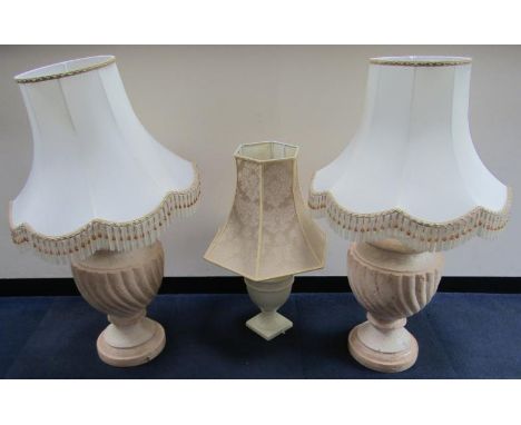 A pair of spiral fluted baluster terracotta table lamps, with shades, 95cm high, and a further table lamp, (3).