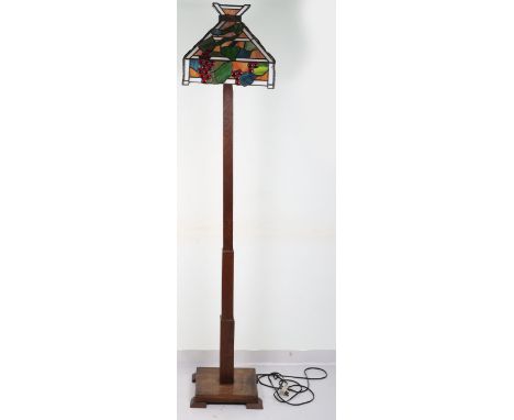 An Arts &amp; Crafts Liberty &amp; Co style coloured glass and wood standard lamp, on oak base, 179cmH including shade Note: 