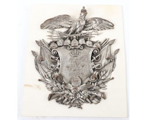 An Imperial German silver plated badge mount, with central MTH above 1887, the shield above a handshake and surrounded by fla