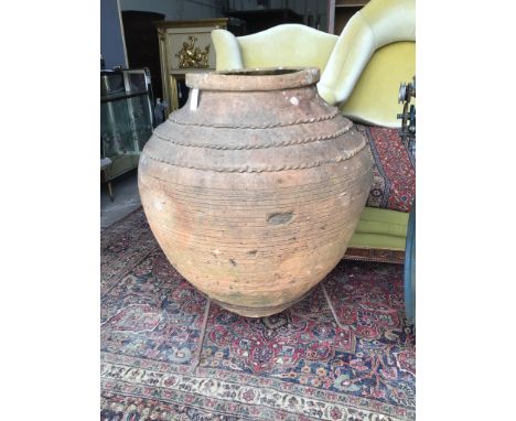 A large Greek style earthenware olive jar on wrought iron stand, height 116cm
