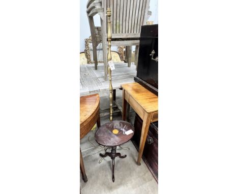 A brass standard lamp on scrolled supports and an oval top mahogany tripod wine table