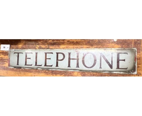 A vintage glass telephone box sign, width 64cm, height 10cm