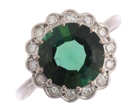 An 18ct white gold green tourmaline and diamond flowerhead cluster ring, centrally claw set with 3ct round step-cut tourmalin