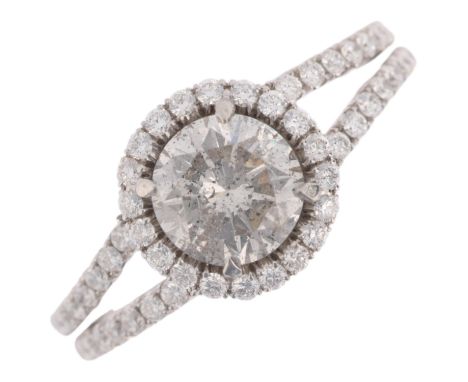 A modern diamond halo cluster ring, centrally set with 1ct modern round brilliant-cut diamond surrounded by row of diamonds w