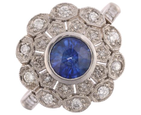 A platinum sapphire and diamond flowerhead cluster ring, maker JC, set with 1ct round-cut sapphire surrounded by single and m
