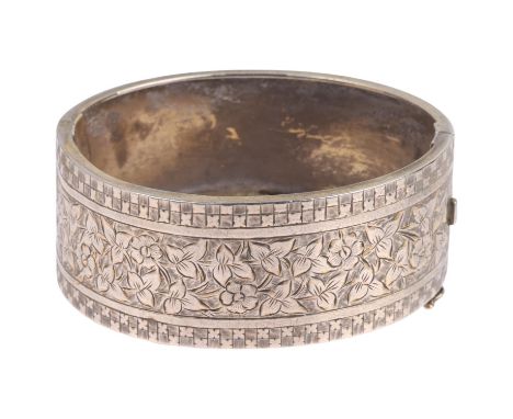 A Victorian sterling silver hinged bangle, engraved floral decoration, band width 24.5mm, internal circumference 16cm, 26.3gG