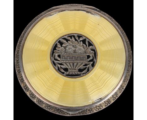 An Art Deco Austrian sterling silver and yellow enamel powder compact, circa 1930, circular form with pierced urn of flowers 