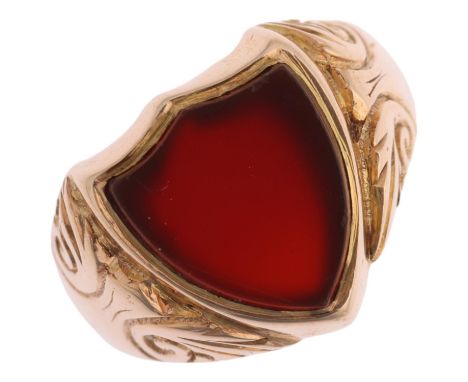 An early 20th century 9ct rose gold carnelian shield seal signet ring, Birmingham 1914, foliate engraved shoulders, shield me