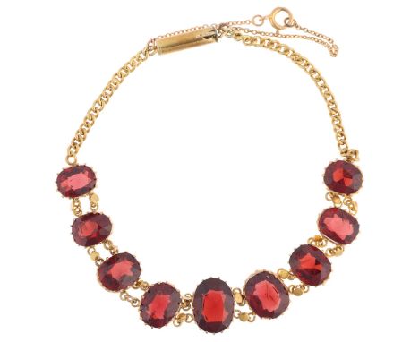 An Edwardian graduated garnet line bracelet, claw set with oval mixed-cut garnets, on curb link chain, apparently unmarked, s