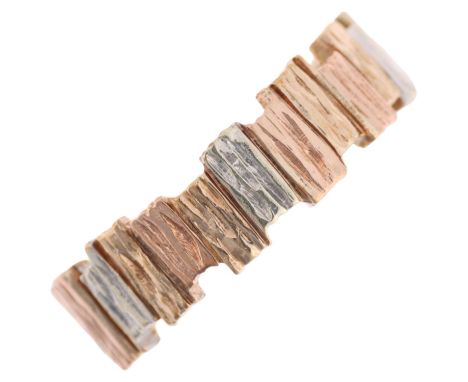 A 1980s 9ct three-colour gold abstract band ring, maker LWJ, Sheffield 1984, textured bark offset block design, band width 6m