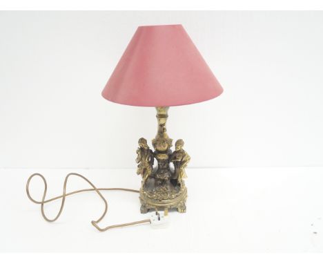 A gilt decorative figural table lamp depicting couple among floral decoration. Lamp shade included. 
