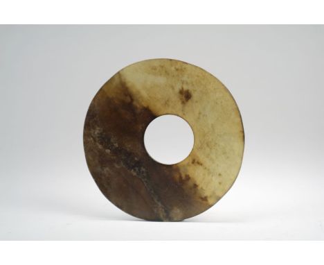 A Chinese grey and russet jade disc, Bi Possibly Neolithic/Liangzhu Culture Of slightly uneven thickness, the semi translucen