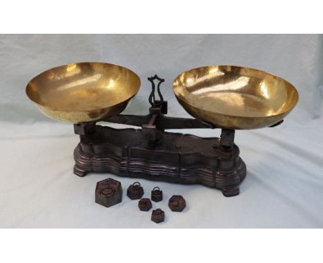 A pair of French brass and cast iron scales, with dished pans, the shaped base cast ''F10K'' together with additional weights