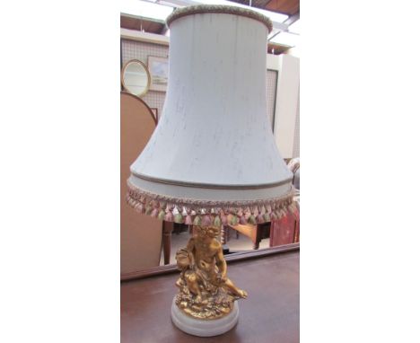 A table lamp, the base with a gilt cherub holding a chalice on a circular base