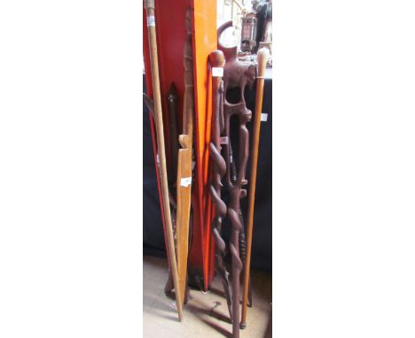 An African carved hardwood walking stick together with a snake carved walking stick, spears, folding stand etc