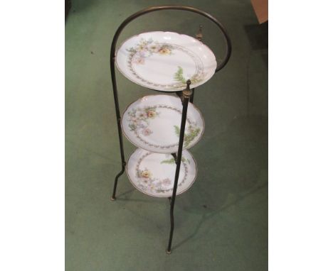 An Edwardian brass three tier cake stand with ceramic plates 