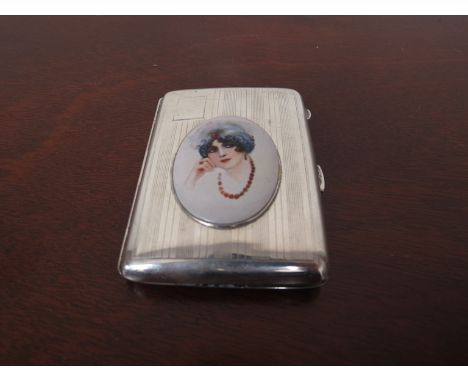 A silver cigarette box with engine turned detail inset with a later porcelain plaque depicting 1930's female in head dress, B