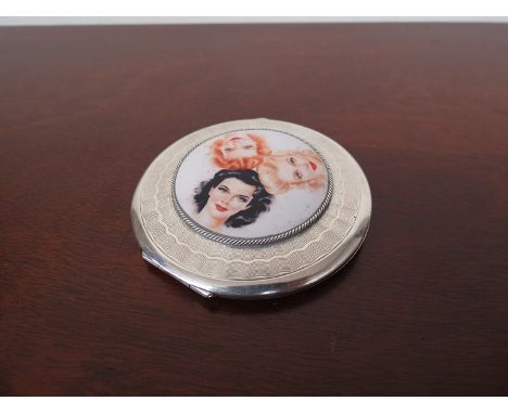 A silver compact with engine turned detail set with later porcelain plaque depicting three female faces, Birmingham 1947, 8cm