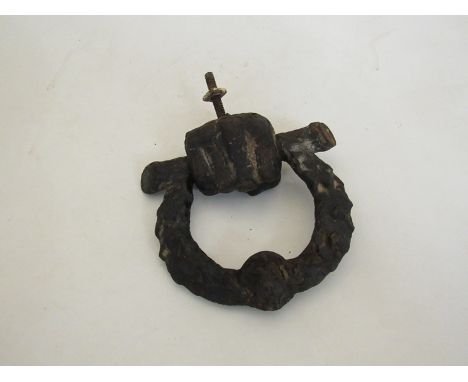 A 19th Century cast iron door knocker of a fist holding a wreath 