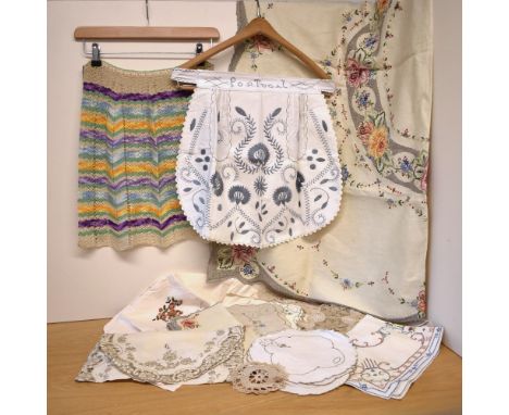 A collection of early-to-mid 20th century domestic linens, comprising two handmade pinafores, an embroidered cotton head cove