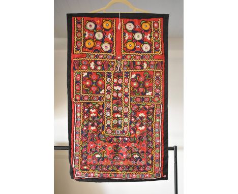 A vintage wall hanging example of Shisha embroidery, characterised by small circular mirrors embedded among yellow-gold, silv