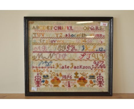 A framed cross stitch sampler, by Kate Jackson aged 14, dated 1896, worked mostly in reds, oranges, and greens, with an geome