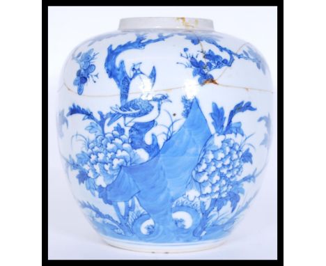 A 17th Century Chinese Kangxi period (1661-1722) ceramic blue and white ginger jar being hand painted with scenes of birds fl