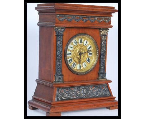 An early 20th Century mantel clock made by British United Clock co. having a gilt face with embossed decoration of cherubs wi