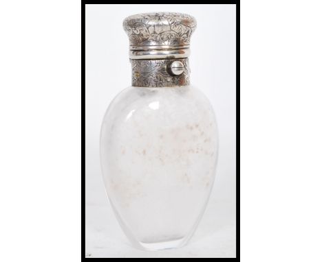 A 19th Century silver topped scent bottle having an ovoid glass body. The lid being decorated in the Rococo manner with folia
