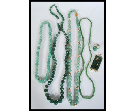 A collection of green stone jade type necklaces along with a green stone and gilt Chinese pendant, ring etc.