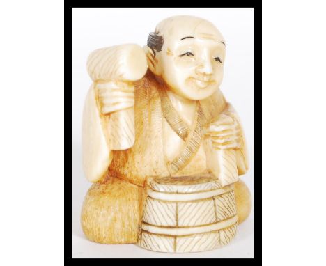 A 19th Century Japanese Meiji period carved ivory netsuke depicting a man working a barrel. Signed to base. Measures 5 cm hig