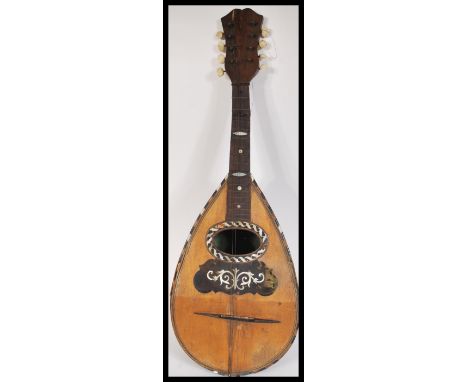 A vintage early 20th Century Mandolin musical instrument. The eight string instrument having tortoiseshell and mother of pear