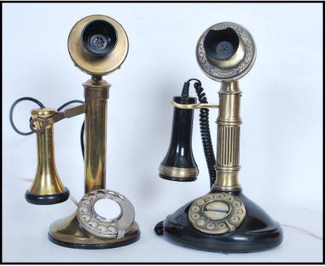 A pair of vintage style brass and bakelite stick telephones, both raised on circular bases with one having a ring dial and th