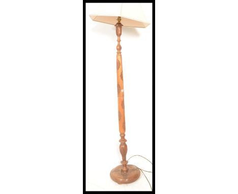 A 20th Century antique style Singapore standard lamp raised on a circular base with tapered column having carved details. Mea
