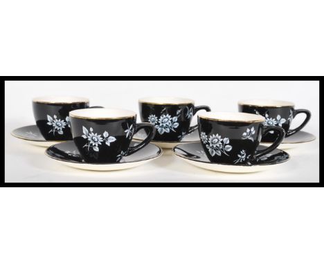 A vintage 20th Century Bristol pottery tea service having a black ground with white floral sprays and gilt rims. Stamped to t