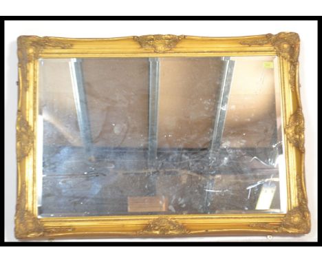 A good quality antique regency revival gilt over mantel wall mirror. The large mirror glass inset to a decorative resin cast 