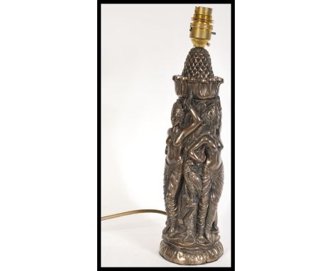 A 20th Century bronze effect resin lamp stand in the form of Asian deities with animal companions including an eagle, cobra s