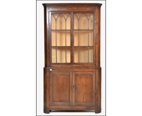 A 19th century large oak corner display cabinet / cupboard. Raised on bracket feet with twin door cupboard enclosing central 