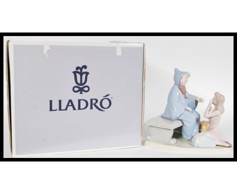 A Lladro ceramic figure entitled Cinderella and The Fairy Godmother 07553 complete in original box. Measures 22 cm high.