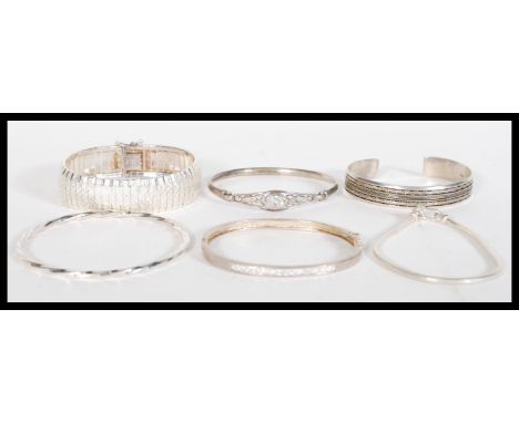 A selection of silver bracelets to include a bangle with a celtic knot design set with a white stone, a bangle channel set wi