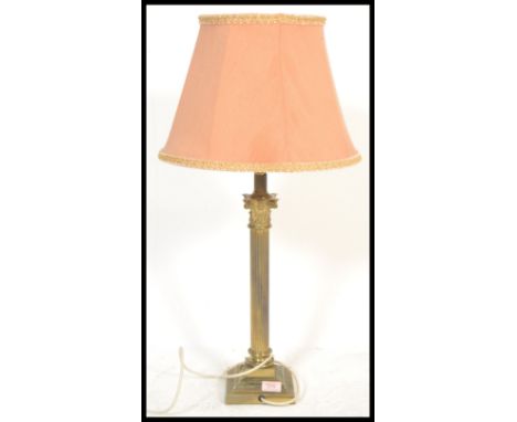 A vintage Antique style brass table lamp raised on paw feet with square base with central brass Classical Corinthian column a