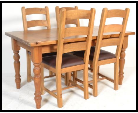 An antique style country pine dining suite consisting of a dining table raised on block and turned legs and a set of four din