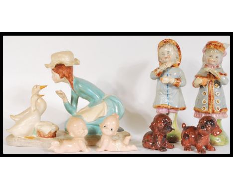 A pair of 19th Century Austrian ceramics modelled as a young boy and girl, together with a pair of ceramic babies crawling et