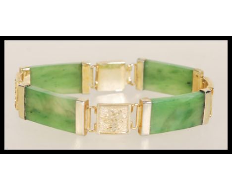 A vintage 20th Century Chinese jade bracelet having yellow metal character mark spacers and hidden clasp. Weighs 22.7 grams.