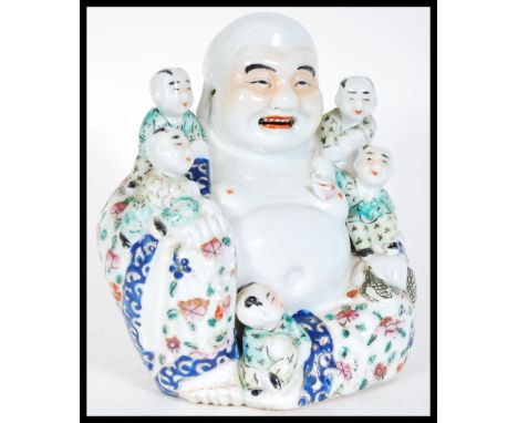 A 20th Century decorative ceramic figure of the laughing Buddha, depicted seated with clambering children, character marks st