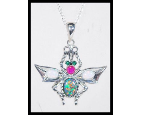 A sterling silver and opal set necklace pendant in the form of a firefly having green stone eyes and red stone body.