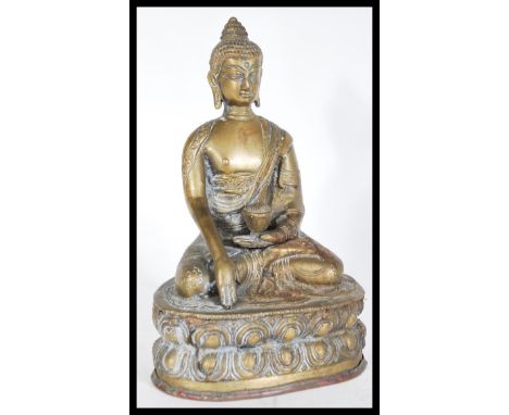 A 20th Century bronze figure of a Buddha in the lotus position wearing decorative robes with one hand holding a bowl and the 