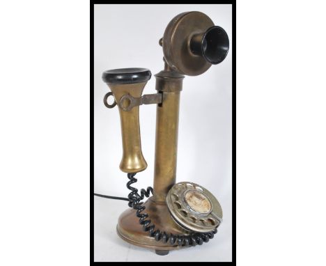 A vintage early 20th Century stick telephone of brass construction having bakelite mouth and earpiece. Measures 32 cm high.