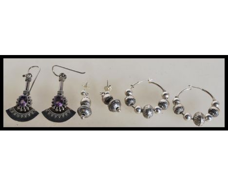 Three pairs of sterling silver earrings to include a pair of circular bead drop earrings, pair of Art Deco axe shape earrings